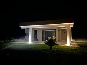 Modernes Bungalow in Menfi bei Nacht – beleuchtete Fassade und überdachte Veranda